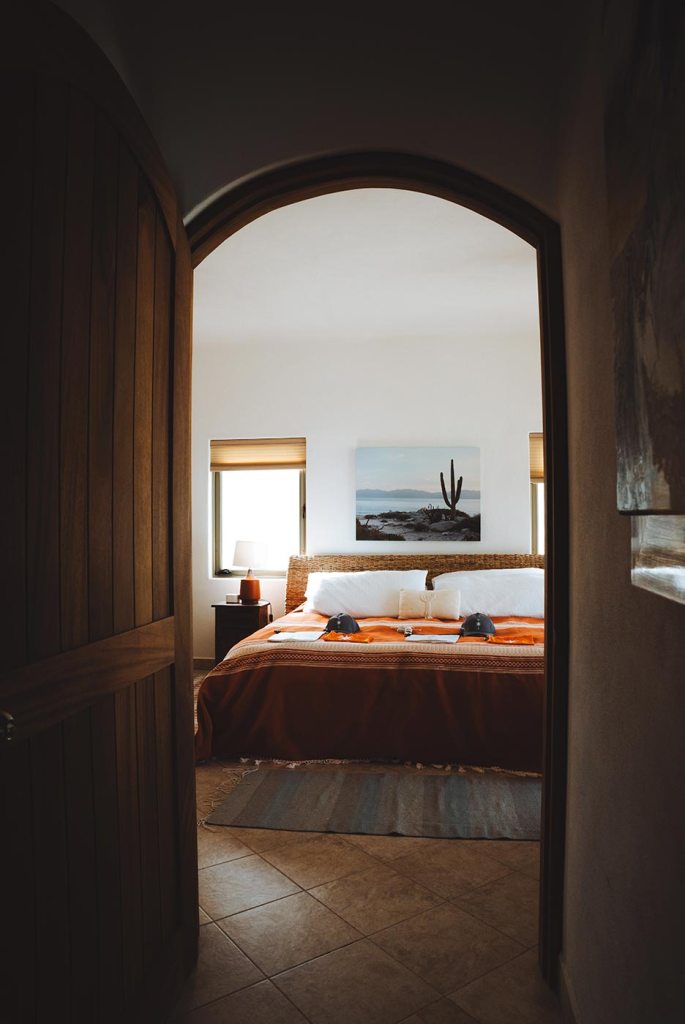 Bedroom viewed through an arched doorway at the expedition accommodation in La Ventana